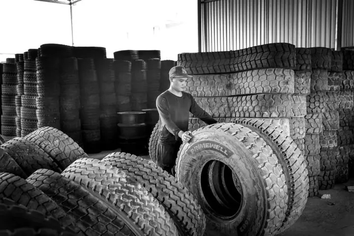 Worker stacking rubber tyres