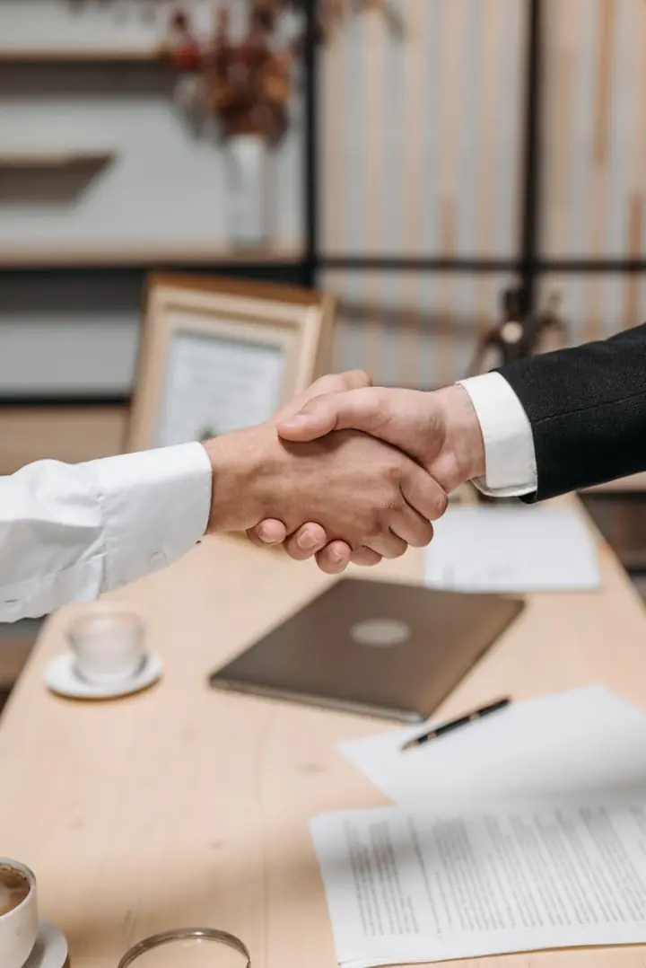 Client and Mesprosoft consultant shaking hands after a project review